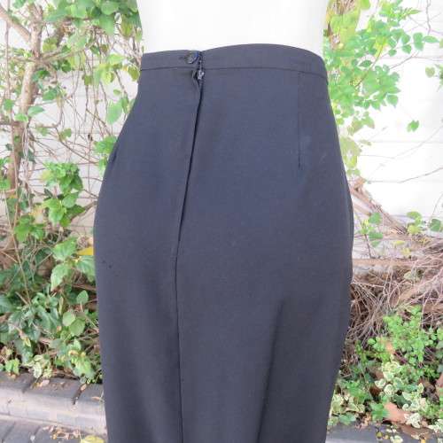 Ankle length black crepe polyester pencil skirt with pleat and zip at back. Size 40/16 by DIANELLO.