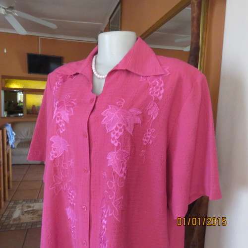Top of the line magenta pink richly embroidered short sleeve bubble polyester top. Size 46. As new