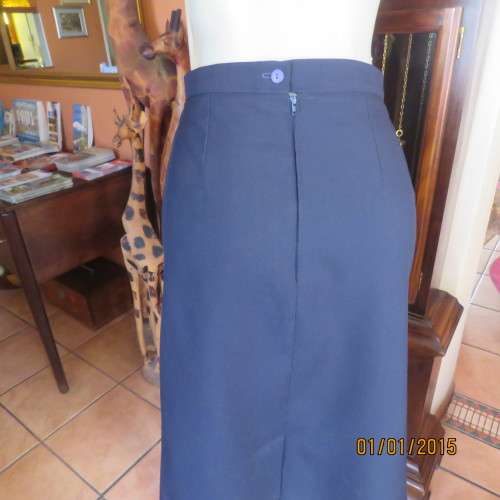 Elegant dark navy polyester pencil skirt. Upper calf length. Zip/pleat at back. Size 42 to 44.As new