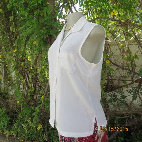 Cool sleeveless summer top in cream polyester. Pretty embroidery on collar and front.Size 36. As new