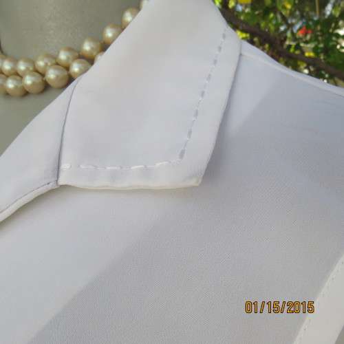 Cool sleeveless summer top in cream polyester. Pretty embroidery on collar and front.Size 36. As new