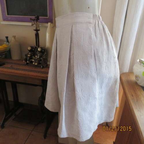 Charming light grey floral embossed poly/nylon knee length skirt.Size 36. Inverted front pleats.