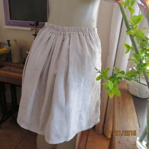 Charming light grey floral embossed poly/nylon knee length skirt.Size 36. Inverted front pleats.