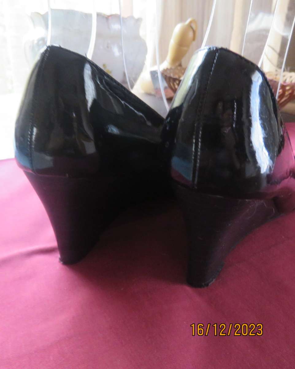 Pair of black shiny patent leather wedge heel shoes by QUEENSPARK size 5. Velvet crossovers.As new
