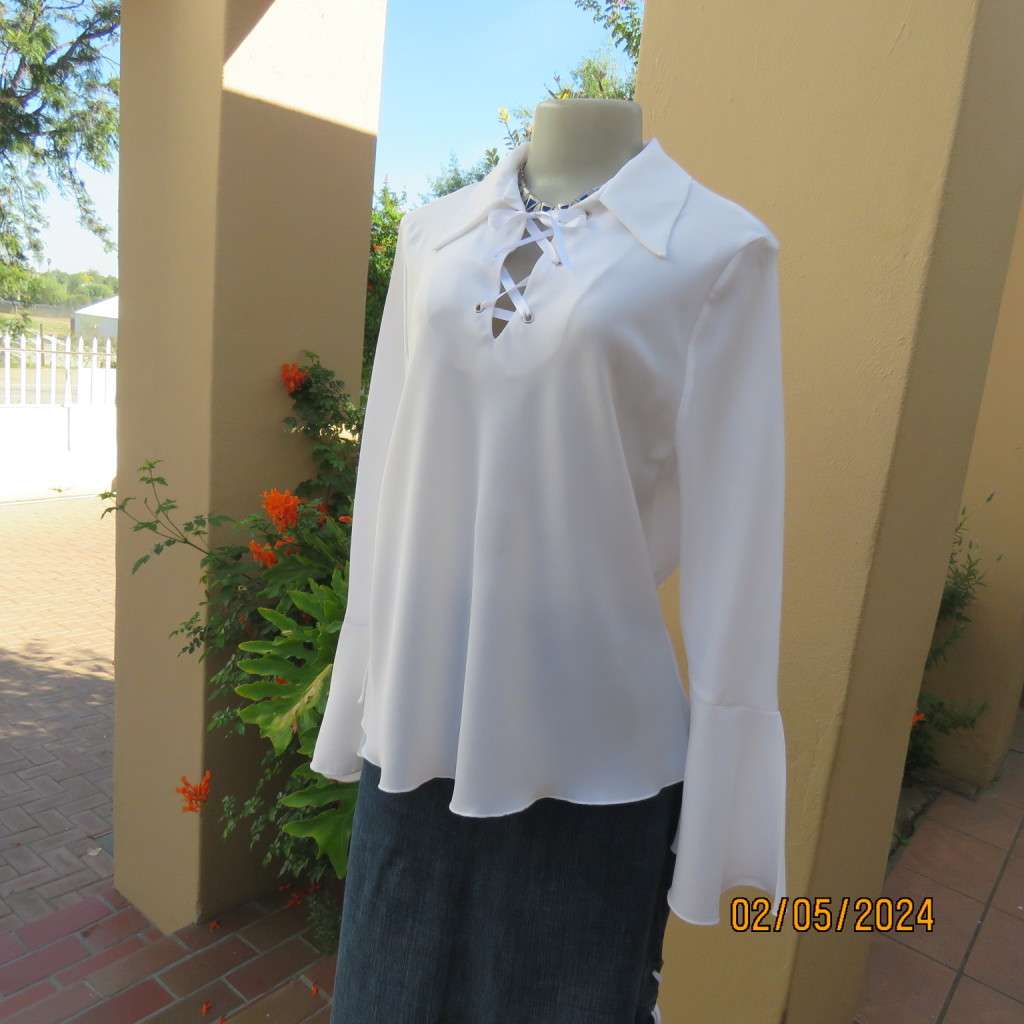 Pretty white polyester slip over top with long sleeves/flare cuffs. Front braided opening.Size 38/40