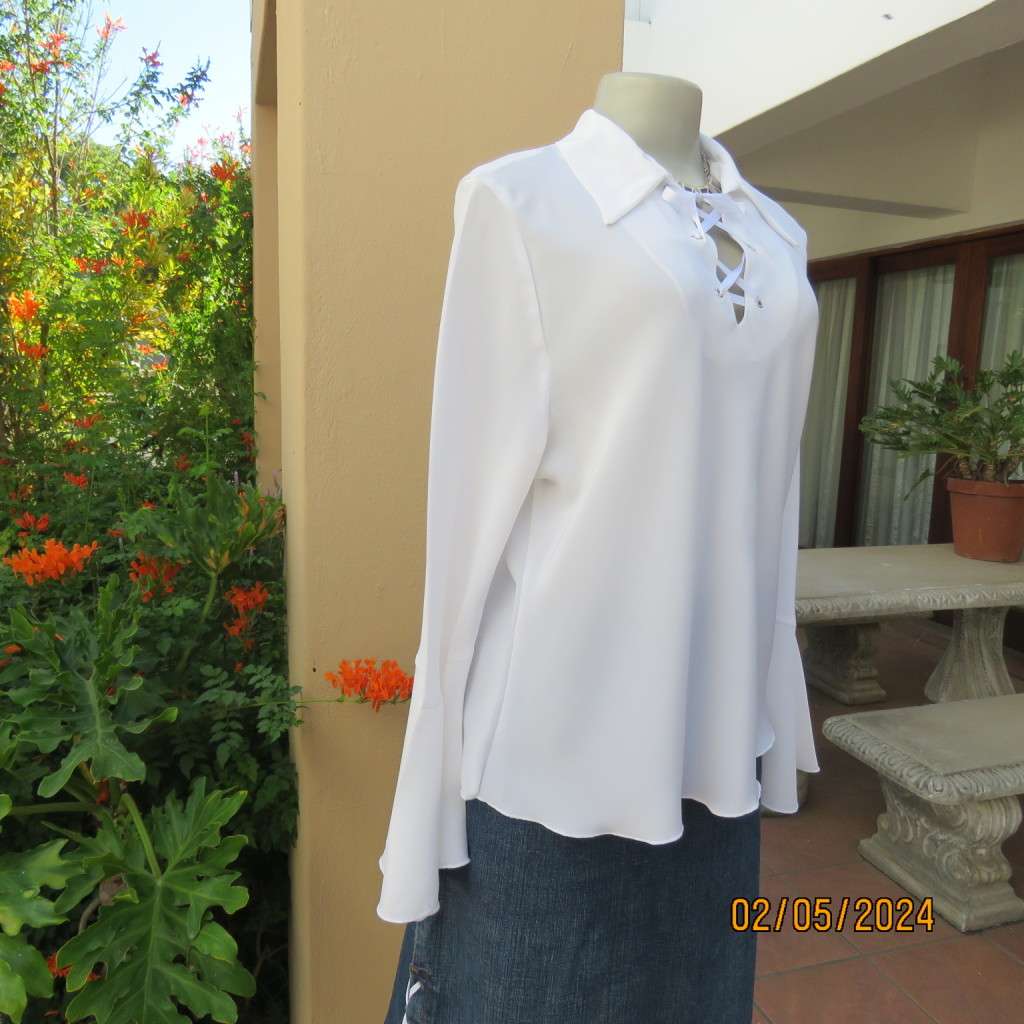 Pretty white polyester slip over top with long sleeves/flare cuffs. Front braided opening.Size 38/40