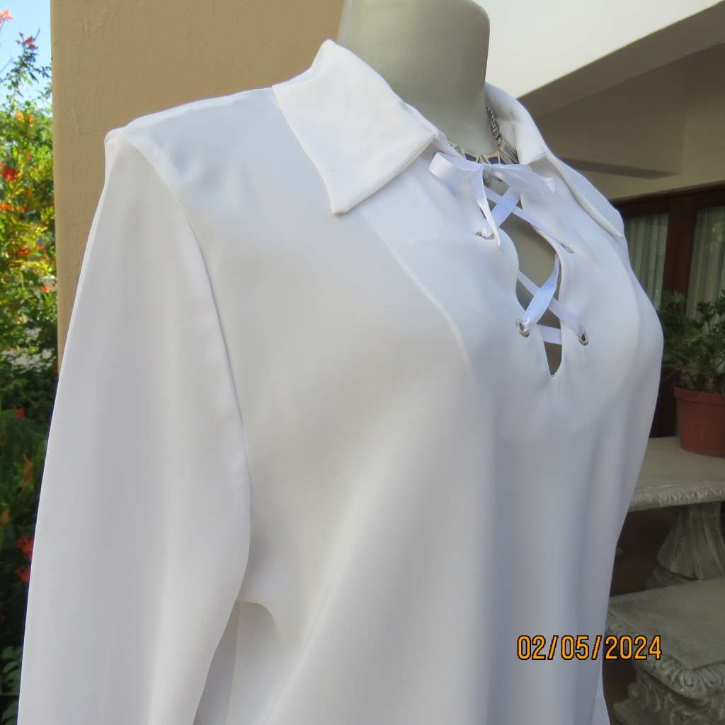 Pretty white polyester slip over top with long sleeves/flare cuffs. Front braided opening.Size 38/40