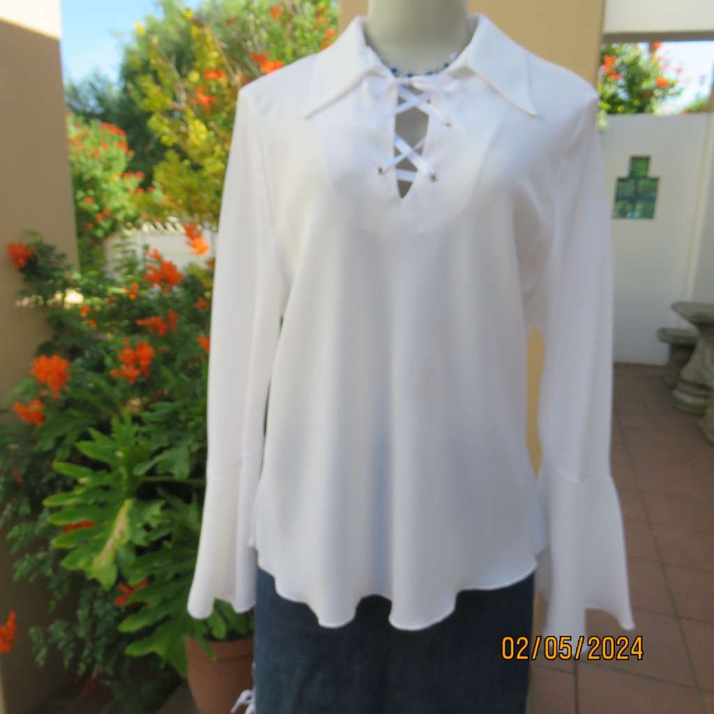Pretty white polyester slip over top with long sleeves/flare cuffs. Front braided opening.Size 38/40
