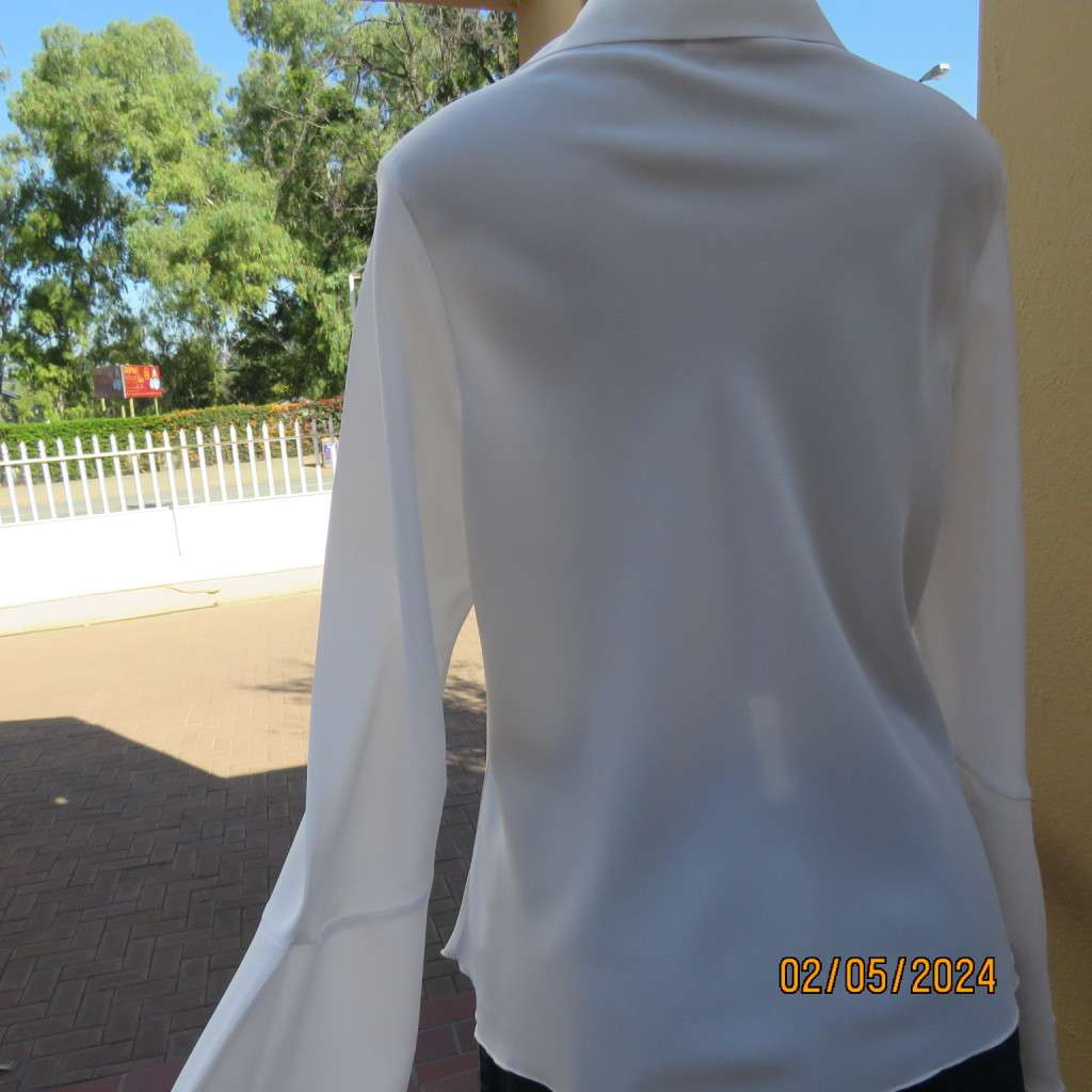 Pretty white polyester slip over top with long sleeves/flare cuffs. Front braided opening.Size 38/40