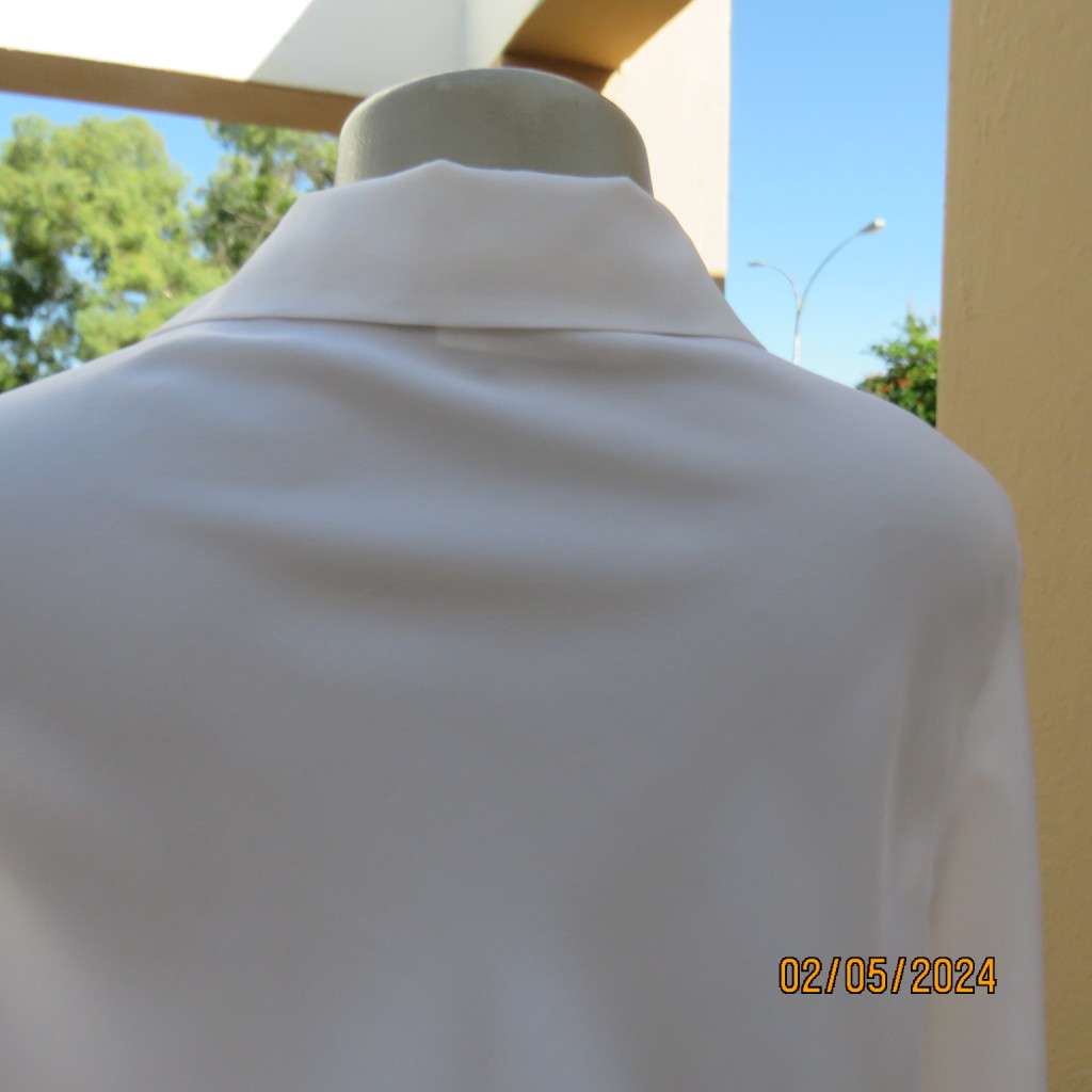 Pretty white polyester slip over top with long sleeves/flare cuffs. Front braided opening.Size 38/40