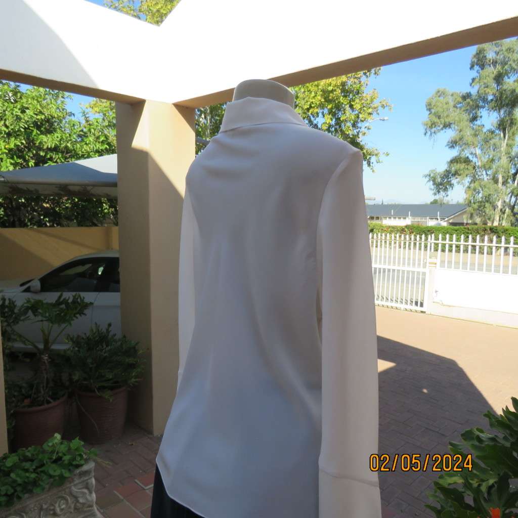 Pretty white polyester slip over top with long sleeves/flare cuffs. Front braided opening.Size 38/40