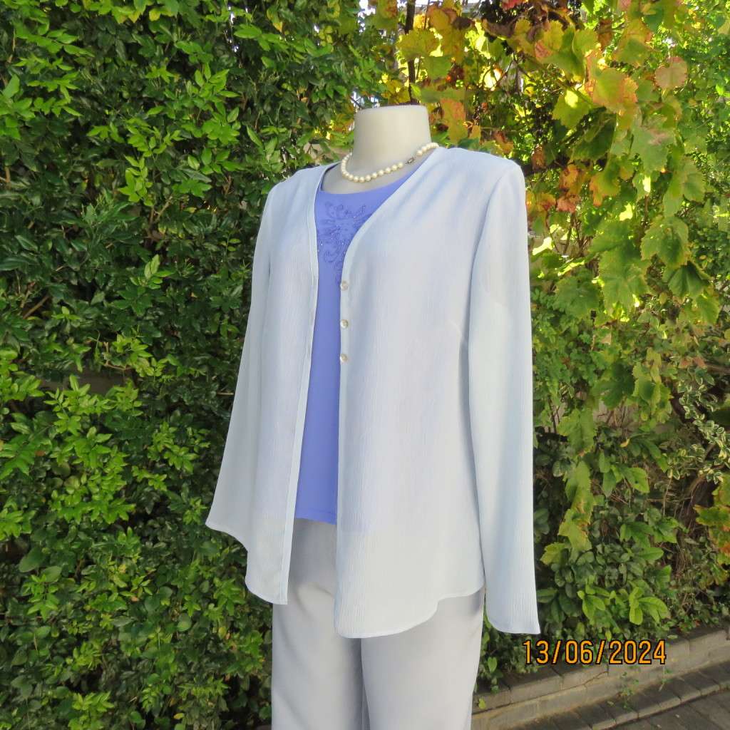 Dainty powder blue long sleeve cover-up in crinkled polyester. 3 tiny button closure.Size 38. As new