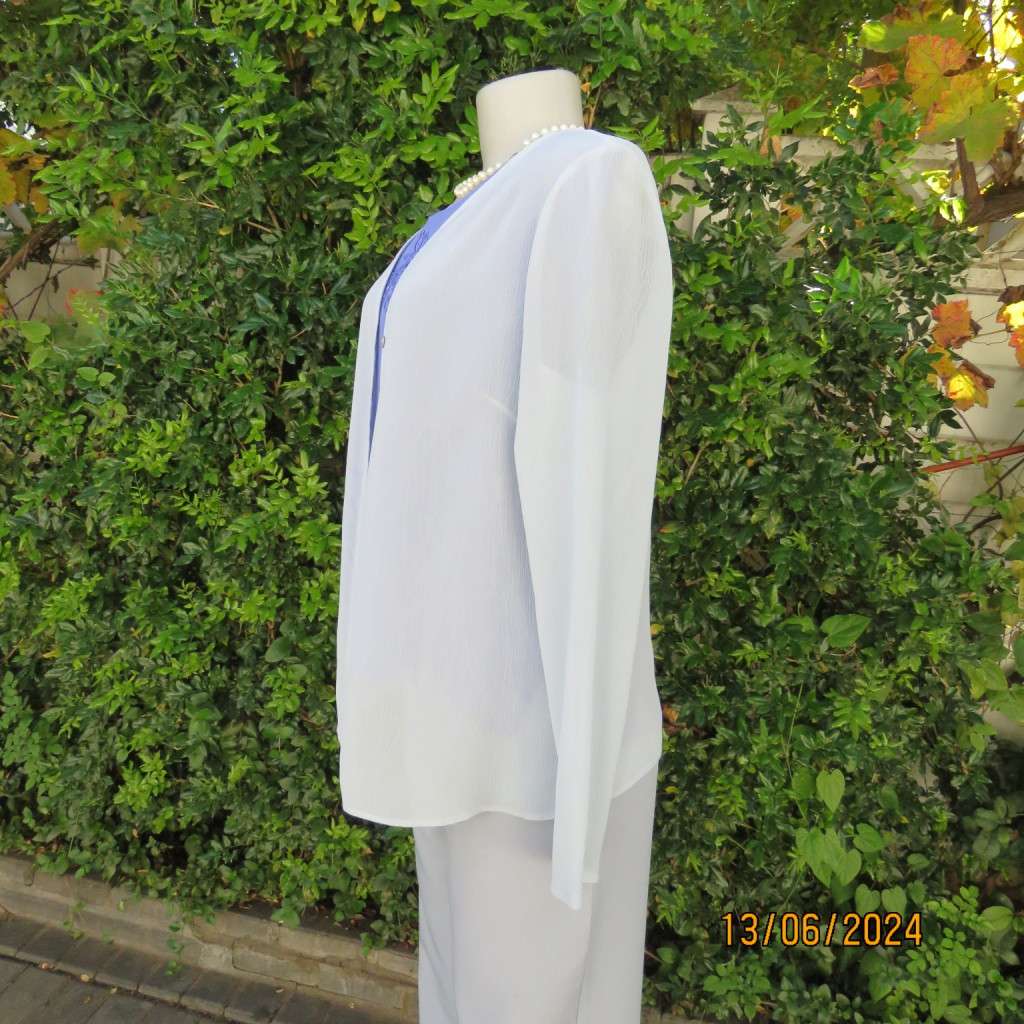 Dainty powder blue long sleeve cover-up in crinkled polyester. 3 tiny button closure.Size 38. As new