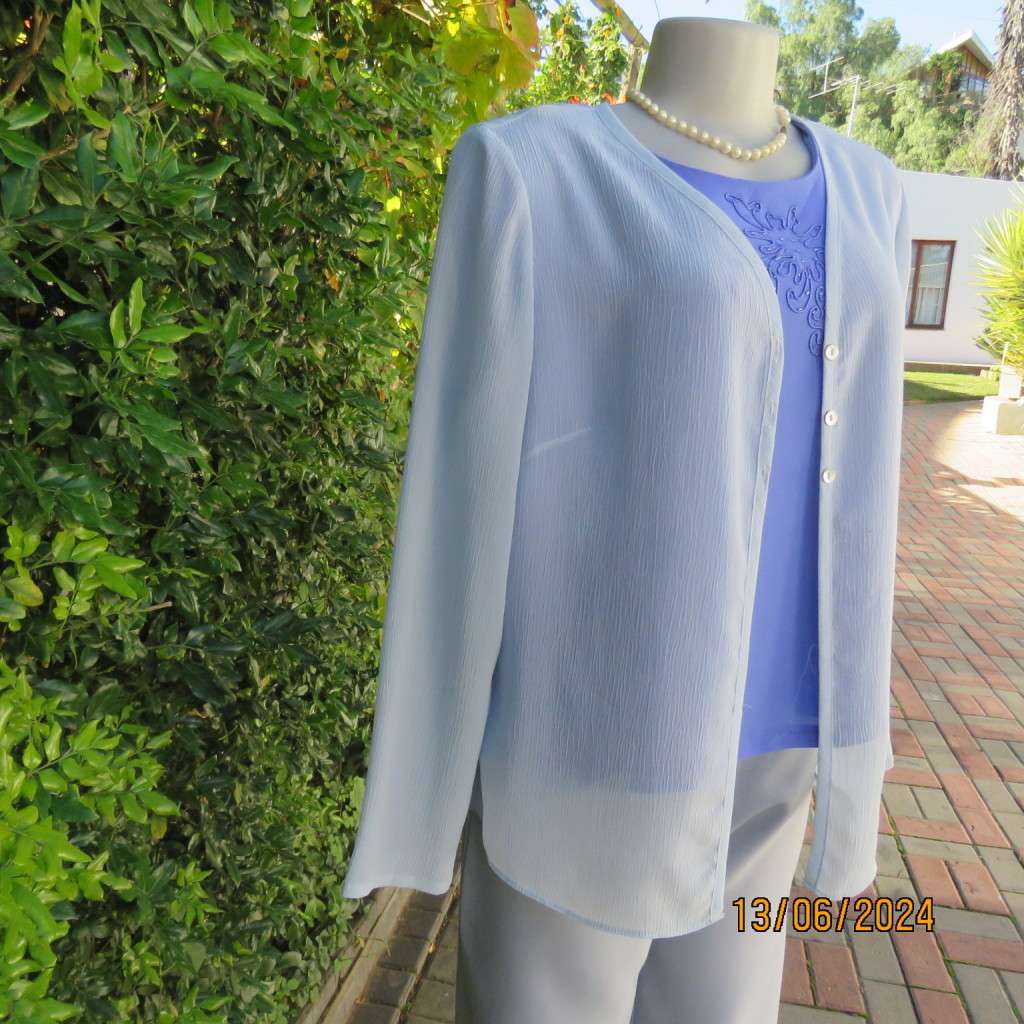 Dainty powder blue long sleeve cover-up in crinkled polyester. 3 tiny button closure.Size 38. As new