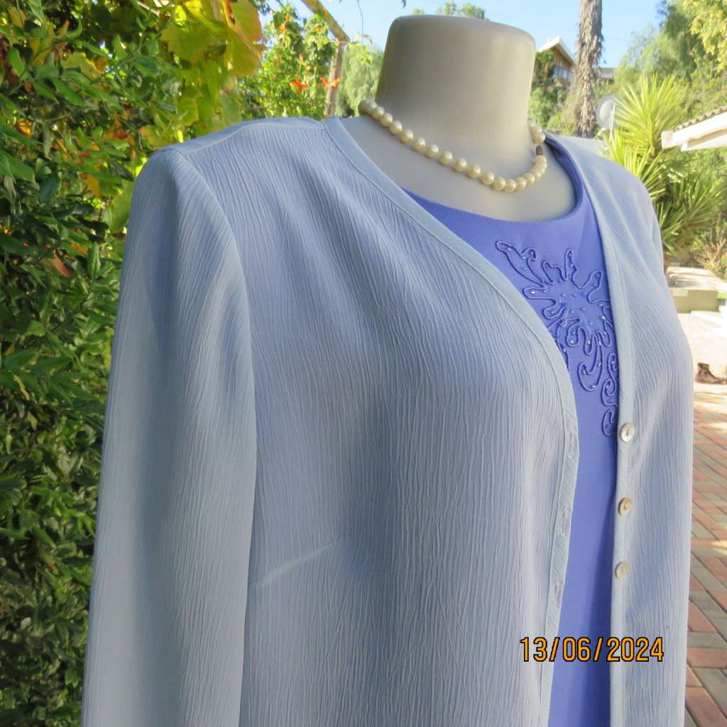 Dainty powder blue long sleeve cover-up in crinkled polyester. 3 tiny button closure.Size 38. As new