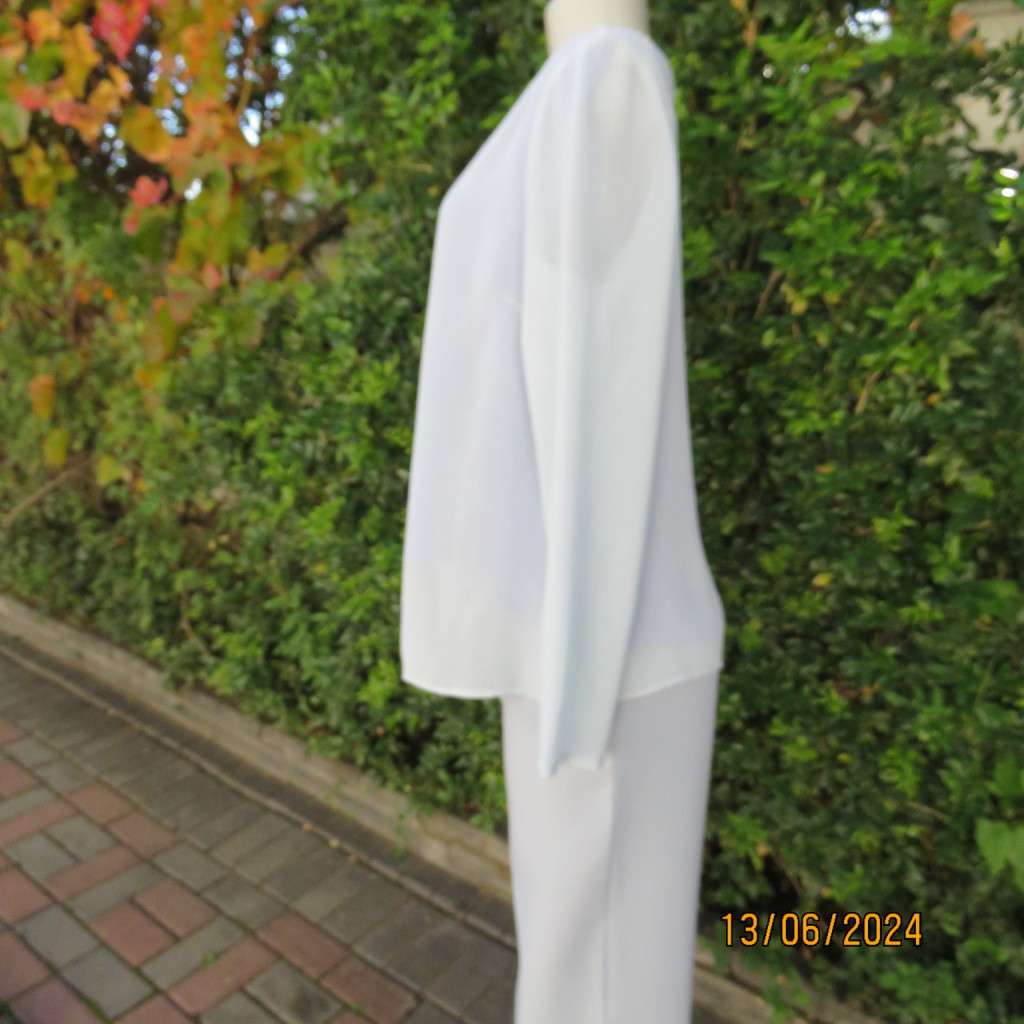 Dainty powder blue long sleeve cover-up in crinkled polyester. 3 tiny button closure.Size 38. As new