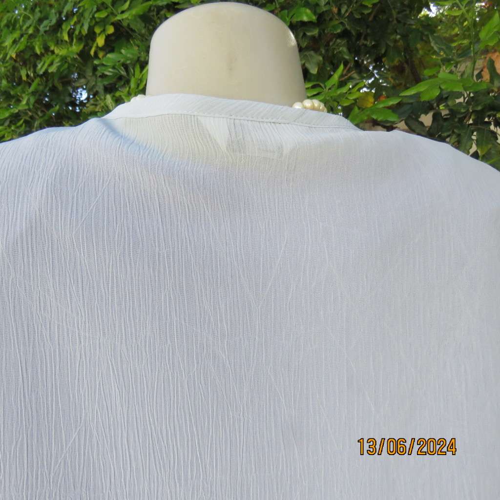 Dainty powder blue long sleeve cover-up in crinkled polyester. 3 tiny button closure.Size 38. As new