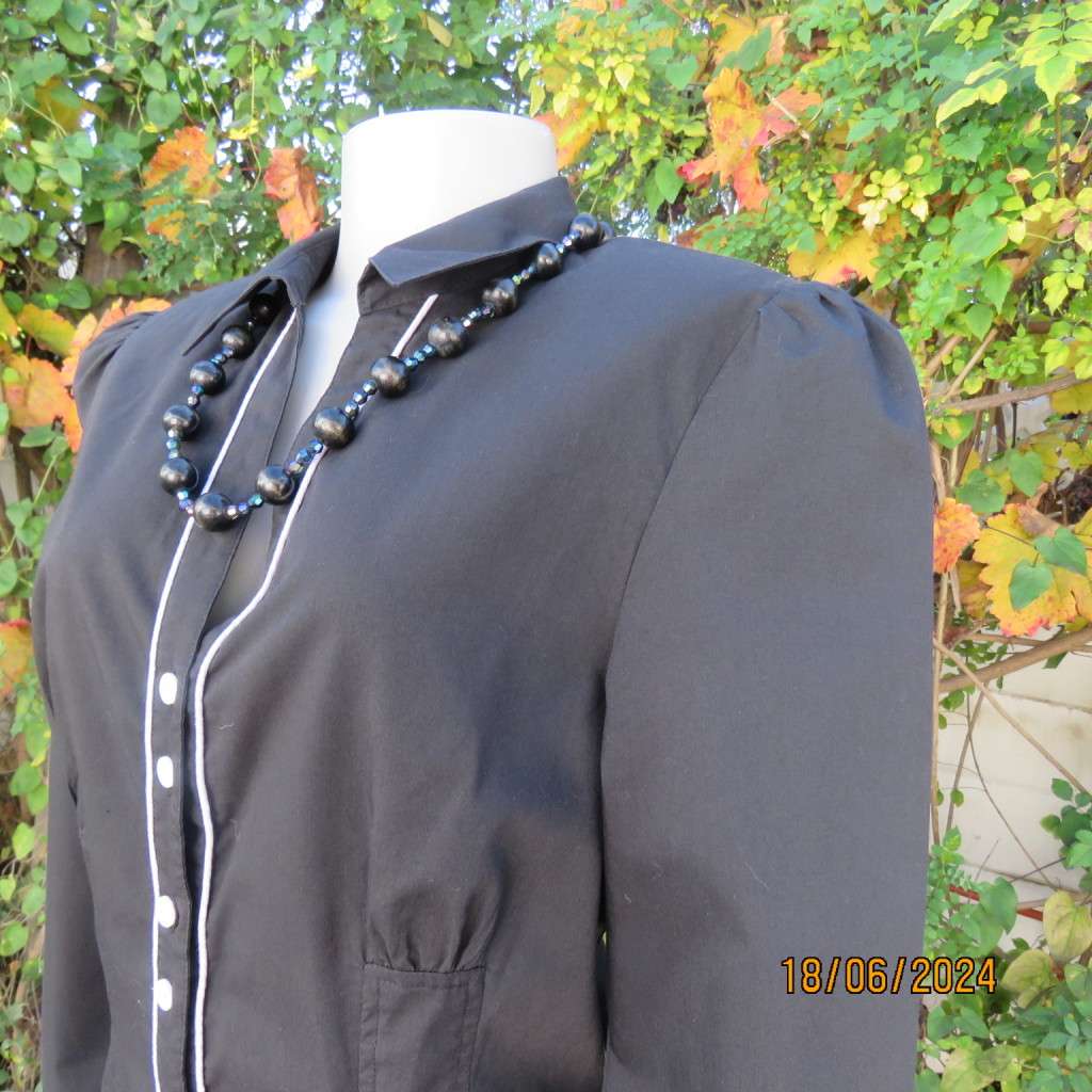 Charming long sleeves black tailored top. V button down front/collar. White edging/buttons.Size 36.