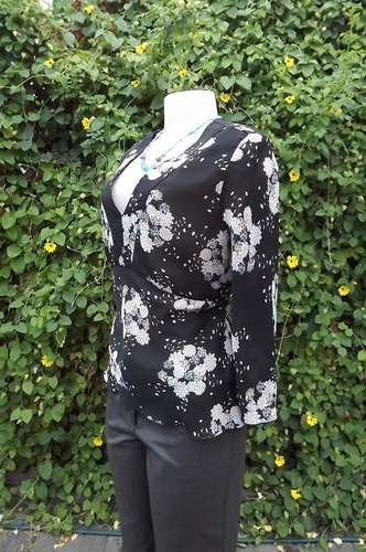 Black sheer polyester V neck top with thin straps at sides to tie at back.By Smiley's size 36/12.