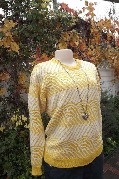 Yellow and white patterned knitted acrylic sweater in size 36/12.Used but good for everyday wear