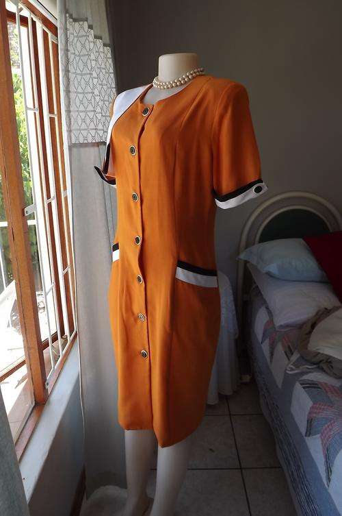 Vintage burnt orange button down dress size 36/12.Black&white cuffs,pockets & side shoulder overlay.