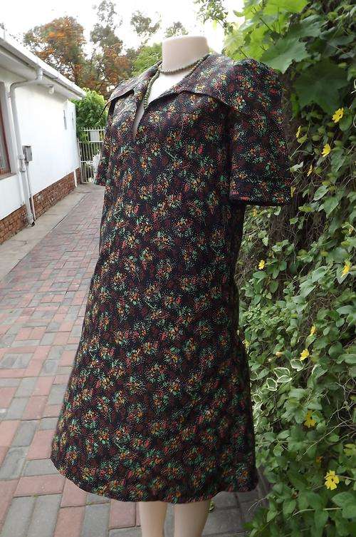 Black dress with small autumn colour flower pattern in rayon/nylon fabric.Size 40/16.Loose style.