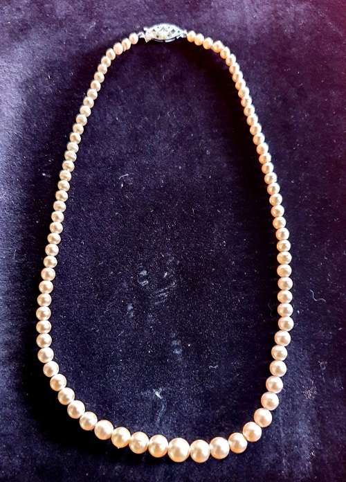ANTIQUE FAUX SINGLE STRING PEARL BEADED NECKLACE WITH ORNATE CLASP.