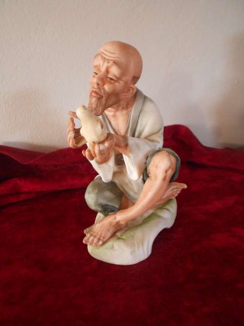 Vintage Oriental Man/Bird in Hand Figurine, marked "Speak to me", Bisque Finish