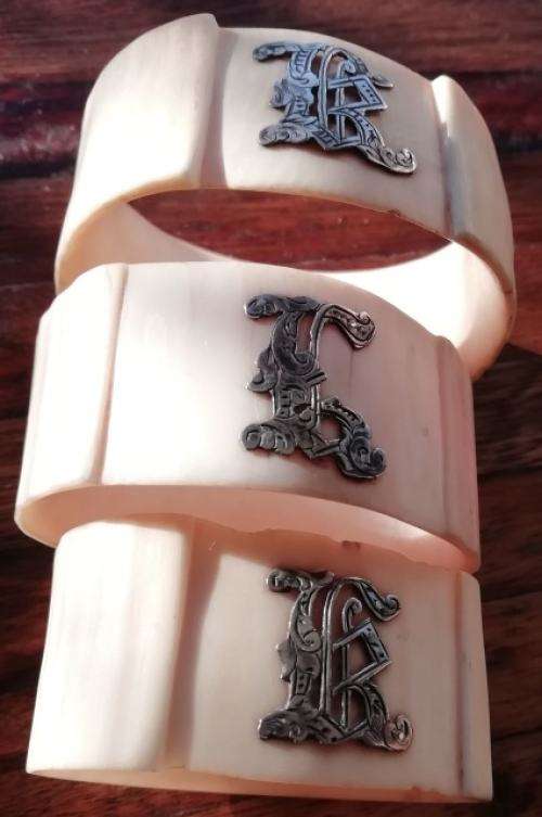 FROM THE VICTORIAN ERA | COLLECTIBLE SET OF 3 IVORY SERVIETTE RINGS EMBELLISHED WITH SILVER LETTERS