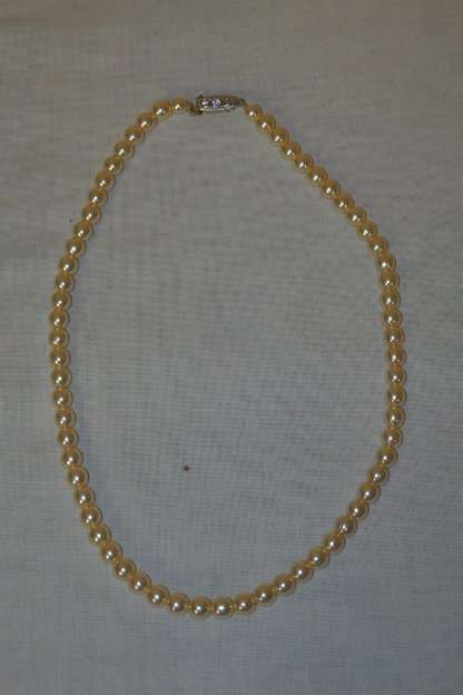 A BEAUTIFUL SINGLE STAND OF FASHION PEARLS WITH AN ELEGANT SILVER METAL CLASP WITH DIAMANTE