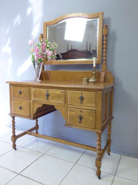 A BEAUTIFUL VINTAGE SOLID OAK DRESSING TABLE WITH 5 DRAWERS AND A LARGE BEVELLED MIRROR ON CASTORS!!