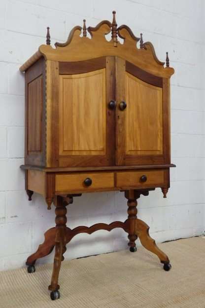 A FANTASTIC VINTAGE GABLED SOLID STINKWOOD AND YELLOW WOOD "PEDESTAL" CABINET ON CASTORS