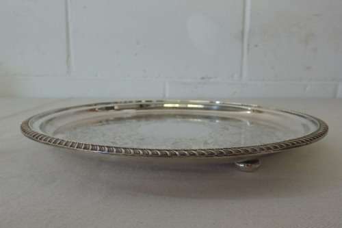 AN EXQUISITE VINTAGE SILVER PLATED ROUND FOOTED SERVING TRAY WITH STUNNING ORNATE ENGRAVED DETAILING