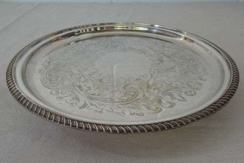 AN EXQUISITE VINTAGE SILVER PLATED ROUND FOOTED SERVING TRAY WITH STUNNING ORNATE ENGRAVED DETAILING