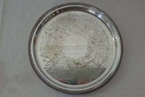 AN EXQUISITE VINTAGE SILVER PLATED ROUND FOOTED SERVING TRAY WITH STUNNING ORNATE ENGRAVED DETAILING