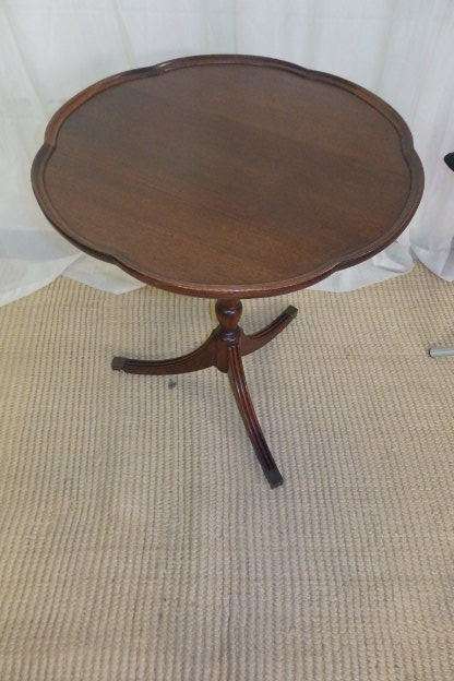 A MAGNIFICENT TEAK OCCASIONAL TABLE WITH BROAD RIMMED DETAILED TOP AND THREE BRASS TOE CAPS
