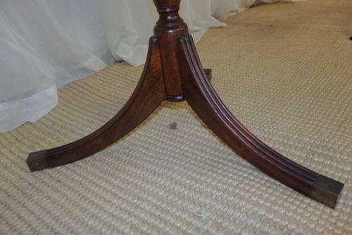 A MAGNIFICENT TEAK OCCASIONAL TABLE WITH BROAD RIMMED DETAILED TOP AND THREE BRASS TOE CAPS