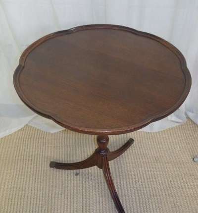 A MAGNIFICENT TEAK OCCASIONAL TABLE WITH BROAD RIMMED DETAILED TOP AND THREE BRASS TOE CAPS