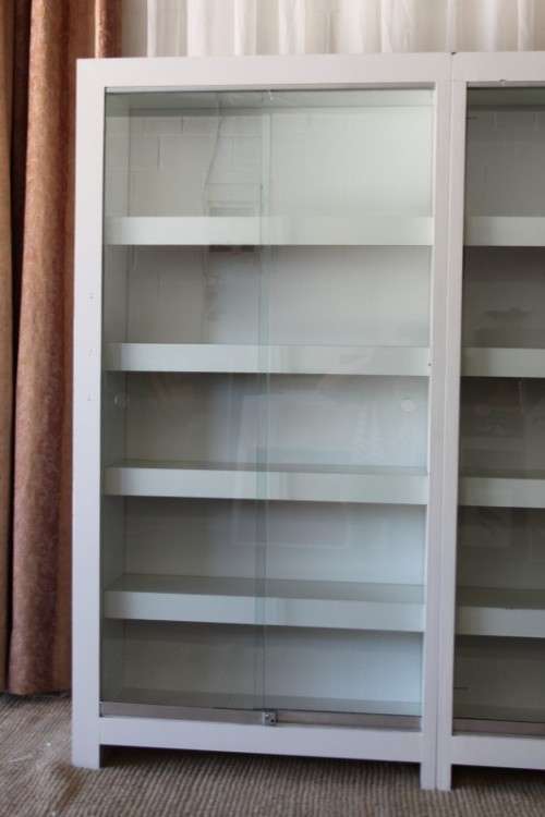 AN AWESOME 1.6m TALL WHITE DOUBLE DIVISION BOOK CASE WITH GLASS SLIDING DOORS & AMPLE PACKING SPACE
