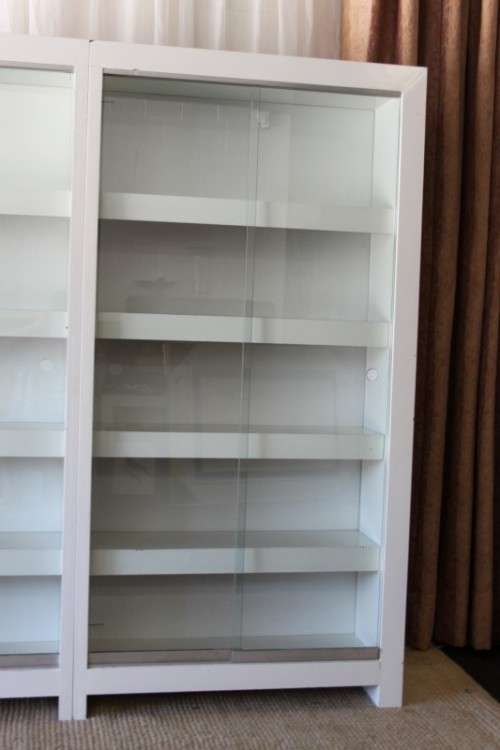 AN AWESOME 1.6m TALL WHITE DOUBLE DIVISION BOOK CASE WITH GLASS SLIDING DOORS & AMPLE PACKING SPACE