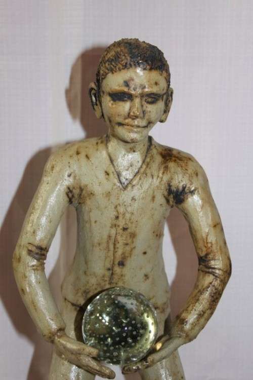 A SUPERB LARGE ONE-OF-A-KIND HAND SCULPTED STONEWARE "MAN" SCULPTURE HOLDING A GLASS BALL