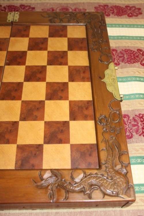 A SUPERB VINTAGE HAND-CARVED ORIENTAL FOLDING CHESS BOARD AND CARVED CHESS SET IN AWESOME CONDITION