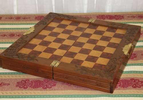 A SUPERB VINTAGE HAND-CARVED ORIENTAL FOLDING CHESS BOARD AND CARVED CHESS SET IN AWESOME CONDITION