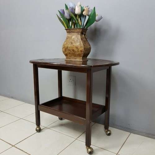 An exquisite Teak "Butlers" trolley on castors with brass hinges; Opens into a removable oval table