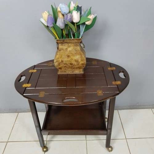 An exquisite Teak "Butlers" trolley on castors with brass hinges; Opens into a removable oval table