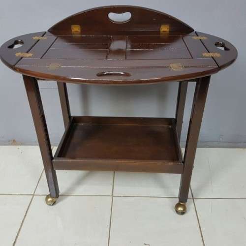 An exquisite Teak "Butlers" trolley on castors with brass hinges; Opens into a removable oval table