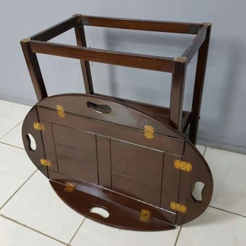 An exquisite Teak "Butlers" trolley on castors with brass hinges; Opens into a removable oval table