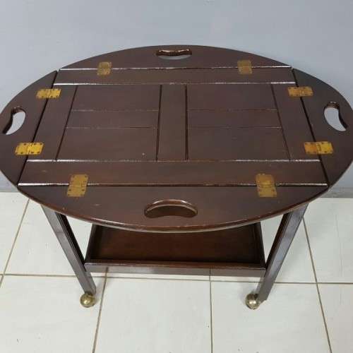 An exquisite Teak "Butlers" trolley on castors with brass hinges; Opens into a removable oval table