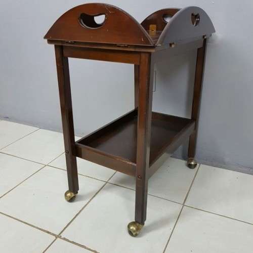 An exquisite Teak "Butlers" trolley on castors with brass hinges; Opens into a removable oval table