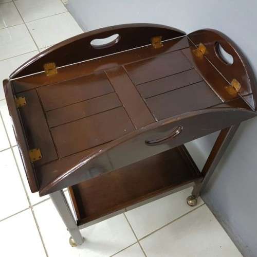 An exquisite Teak "Butlers" trolley on castors with brass hinges; Opens into a removable oval table